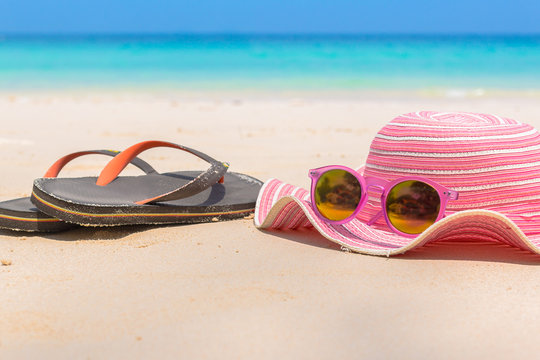 Summer accessories , hat , sunglasses , slippers on sand beach o