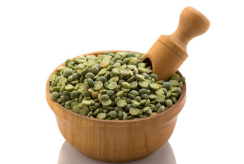 Green peas in a wooden bowl with a spatula