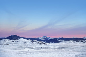 Winter landscape with mountains. Sunset sky. Snow day.