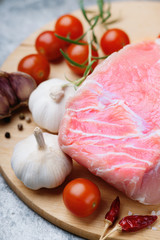 Raw pork on cutting board and vegetables 
