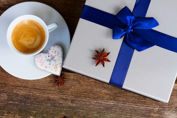 Valentines day cup of coffee with presemt box on wooden table