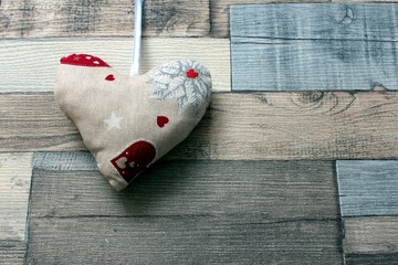 Cloth handmade Valentine&acute;s heart hanging on wooden background.