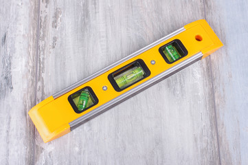 Spirit level tool isolated on reclaimed wood background