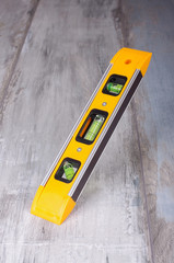 Spirit level tool isolated on reclaimed wood background