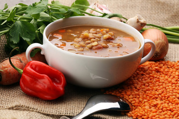 Lentil soup with pita bread in a bowl on a wooden background