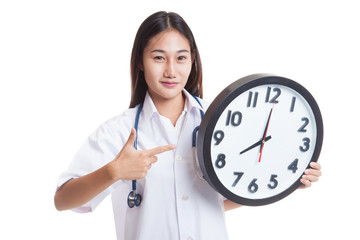 Young Asian female doctor point to a clock.