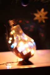 Filament lamp full of garland's lights/ Low light, low depth of field