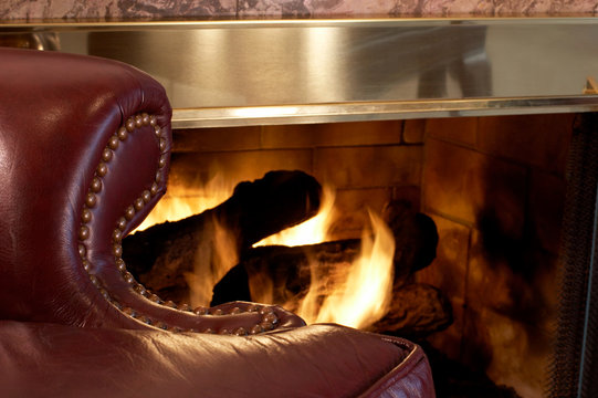 Burgundy Leather Chair By A Roaring Gas Log Fireplace