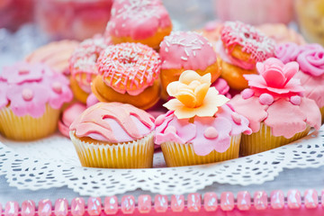 Cupcakes with pink glaze and sweet roses closeup