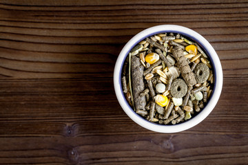 dry food for rodents in bowl wooden background top view