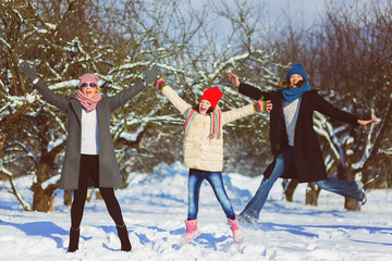 Fototapeta na wymiar Happy family. Two woman and girl a winter walk in nature