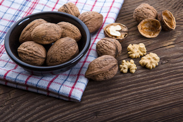 Walnut kernels and whole walnuts on old wooden table