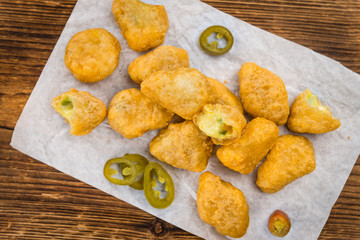 Wooden table with Chili Cheese Nuggets (selective focus)