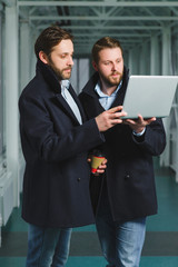 Two handsome businessmen working together on a project at lobby