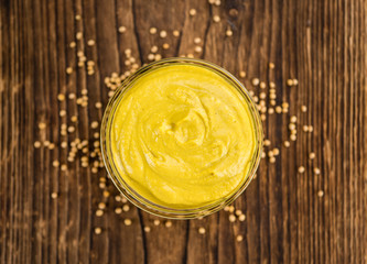 Mustard (selective focus) on vintage wooden background