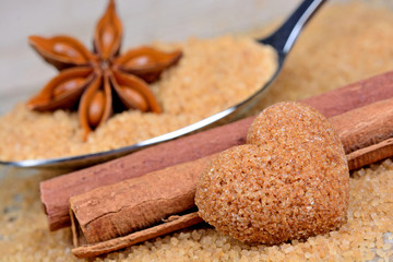 Spoon with sugar and anise star on table