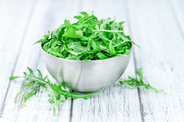 Wooden table with fresh Arugula
