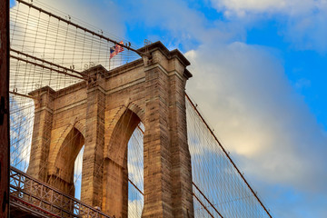 The Brooklyn Bridge, New York. Architectural detail at summer sunset.