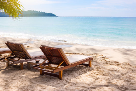 Beach chairs on the white sand beach with  blue sky and sun