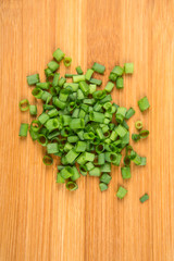 Green onions chopped and stalks isolated on a wood background