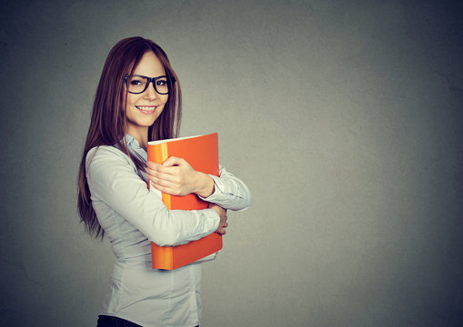 Young happy smiling business woman with orange folder