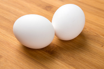 Whole white eggs isolated on a wood background