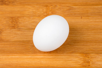Whole white eggs isolated on a wood background