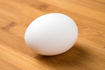 Whole white eggs isolated on a wood background