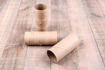 Three empty toilet paper rolls isolated on a wood background