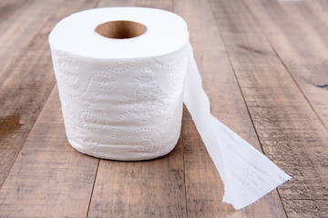 One roll of toilet paper isolated on a wood background