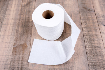 One roll of toilet paper isolated on a wood background