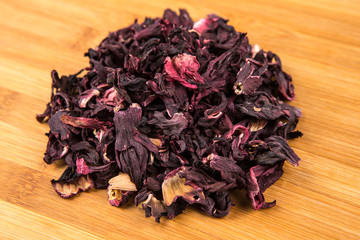 Dried hibiscus flower petals isolated on a wood background