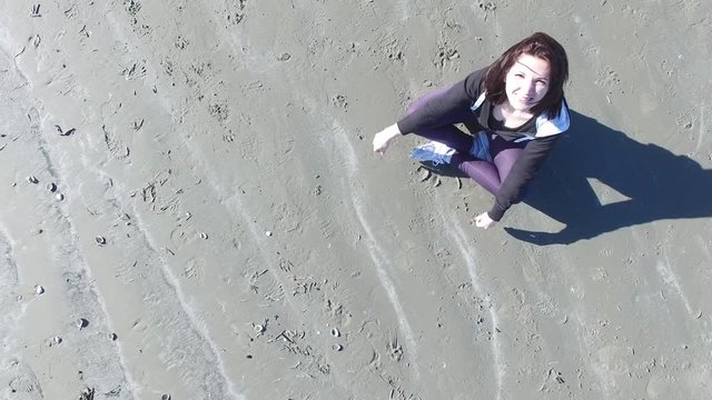 4k aerial footage of a girl doing yoga on the seaside