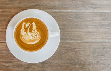 Close up white cup of Coffee, latte with beautiful latte art on the wooden table.