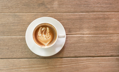 Close up white cup of Coffee, latte with beautiful latte art on the wooden table.