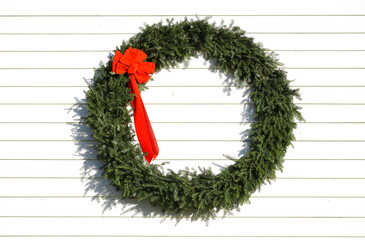 Christmas wreath hanging on white wall