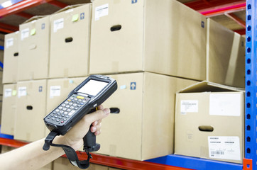 Hands holding portable barcode scanner in warehouse - obrazy, fototapety, plakaty