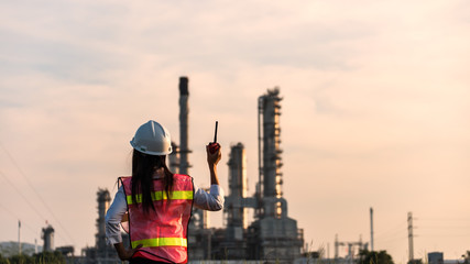 Double exposure of Engineer with safety helmet in front of Oil refinery and gas industry - refinery at sunset background, Business Insustrail concept.