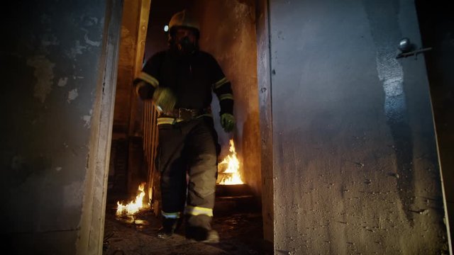 Two Firefighters Descent on Burning Stairs and Go Into Open Doors. Building is on Fire. Fire is Seen Everywhere.  Shot on RED EPIC (uhd).