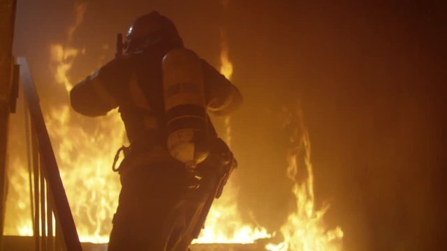 Brave Firefighter Runs Up The Stairs. Raging Fire is Seen Everywhere.  Shot on RED EPIC (uhd).