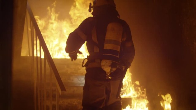 Brave Firefighter Runs Up The Stairs. In Slow Motion. Raging Fire is Seen Everywhere.  Shot on RED EPIC (uhd).
