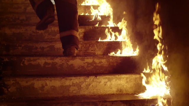 Close-up of a Firefighter's Legs Running Up the Burning Stairs. Building is on Fire Open Flames are Seen Everywhere. Slow Motion.  Shot on RED EPIC (uhd).