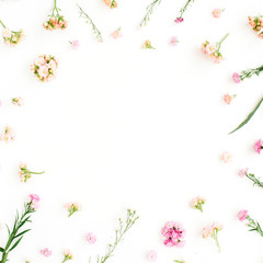 Obraz na płótnie Canvas Frame with pink and beige wildflowers, green leaves, branches on white background. Flat lay, top view. Valentine's background