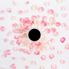 Coffee cup and pink roses petals pattern. Flat lay, top view