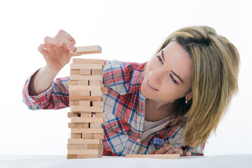 Risk and strategy, planning, hand gambling placing wooden block on tower. Girl builds a pyramid of...