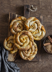 Pumpkin cinnamon buns on a wooden cutting board, top view