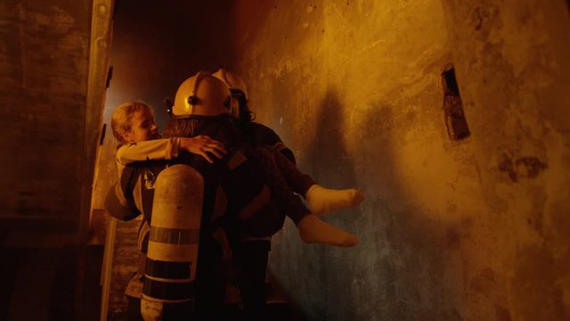 Building is On Fire. Brave Fireman Passes On Saved Girl To His Teammate. Who Brings Her To Safety.  Shot on RED EPIC (uhd).
