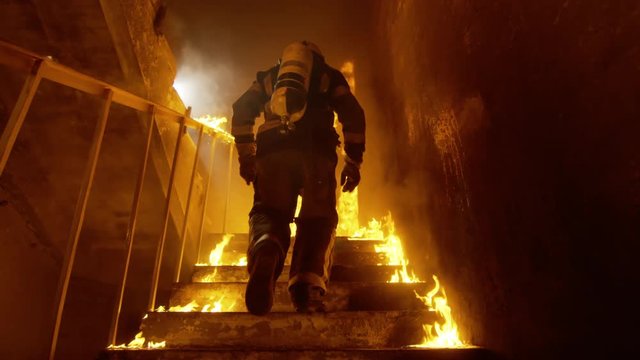Brave Fireman Runs Up the Burning Stairs. Fire is Everywhere. In Slow Motion. Shot on RED EPIC (uhd).