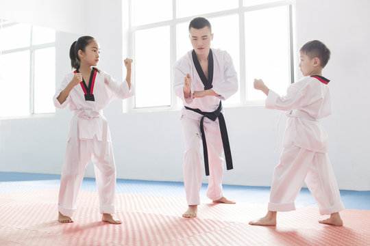 Young instructor teaching children Tae Kwon Do