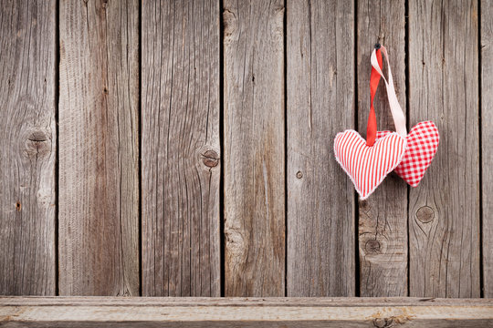 Two Valentines day hearts on rustic wooden wall